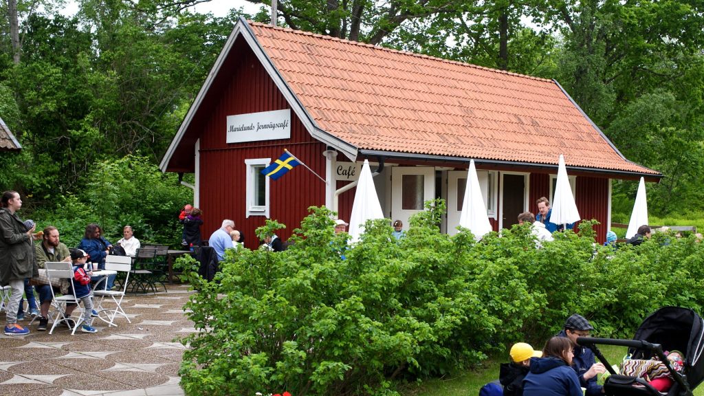 Marielunds jernvägscafé med en röd byggnad i trädgårdsmiljö